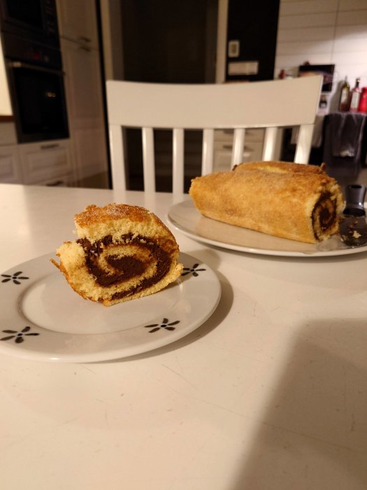 En rulltårta skuren i bitar på tallrikar i ett modernt kök.