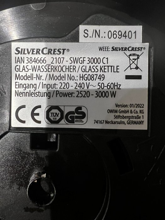 Produktetikett för SilverCrest glasvattenkokare med modellnummer, inspänning och effektinformation, samt certifieringssymboler.