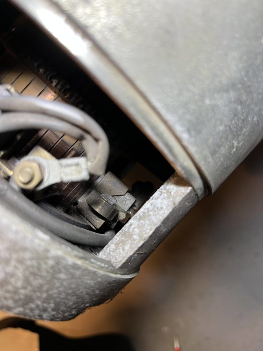 Närbild på vad som ser ut att vara en del av en mekanisk eller elektrisk apparat, möjligen en motor eller generator.