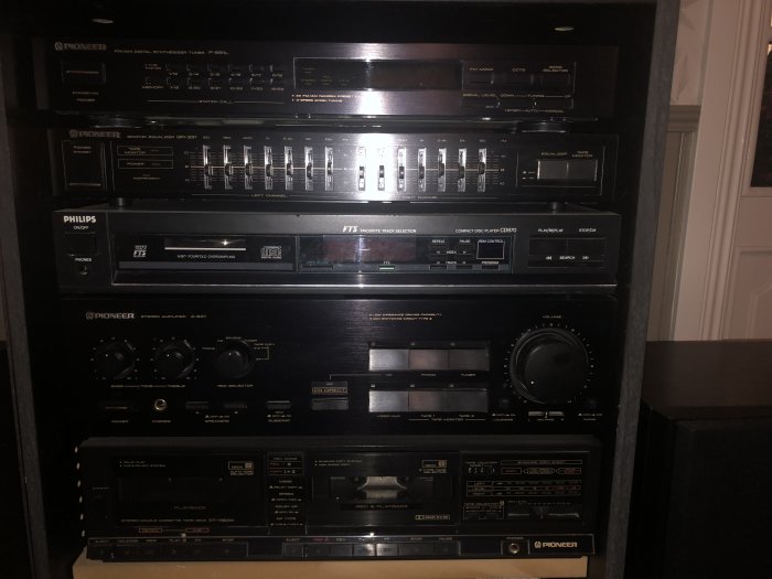 Vintage ljudutrustning i rack, inkluderar förstärkare, equalizer, CD-spelare och tuner från Pioneer och Philips.