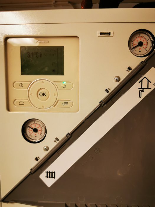 Värmepumpsdisplay visar 31 grader. Tryckmätare, knappar och symboler. Teknisk utrustning, inomhusinstallation.