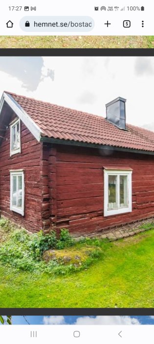 Rött trähus, tegeltak, vitmålade fönster, skorsten, grönskande trädgård, traditionell svensk landsbygdsarkitektur.