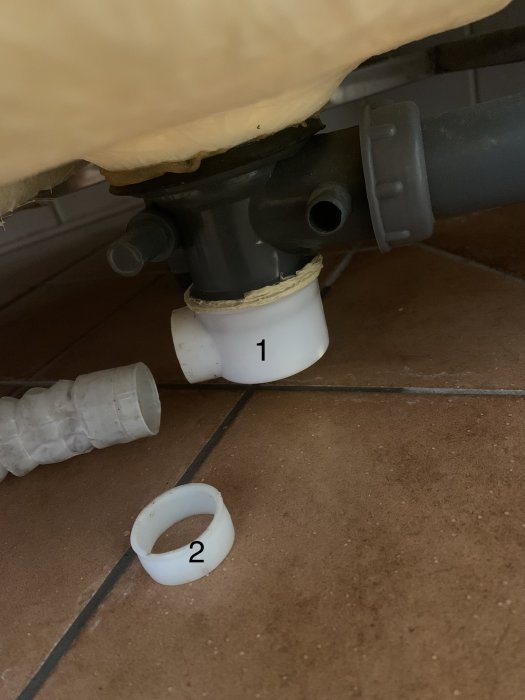 VVS-installation under diskbänk, avloppsrör, numrerade delar, tätning behövs.