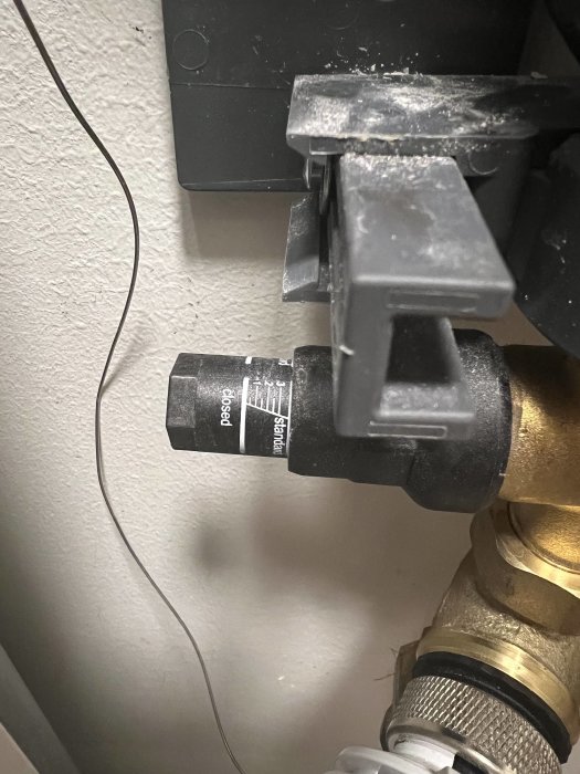 Rördel med etiketterad aktuator, kablar, väggmonterad låda, metallrörskopplingar, industriellt eller hushållsinstallation.