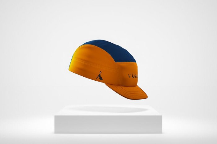 Gul och blå keps med logotyp och figur, framställd i 3D, svävande ovanför en vit fot.