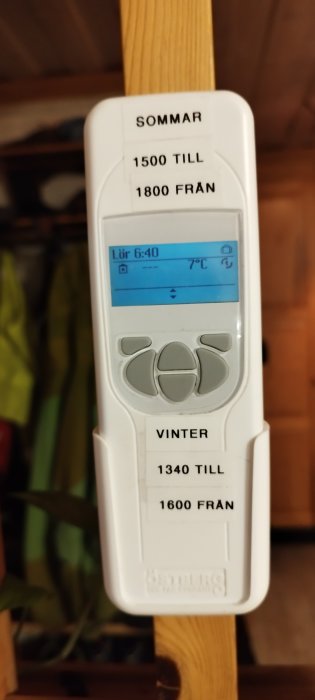 Digital termostat visar tid, temperatur och inställningar för sommar och vinter på svenska.