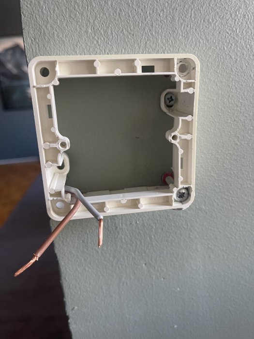 Öppen elektrisk väggdosa med oskyddade kablar och utan strömbrytare eller uttag, installationsprocess.