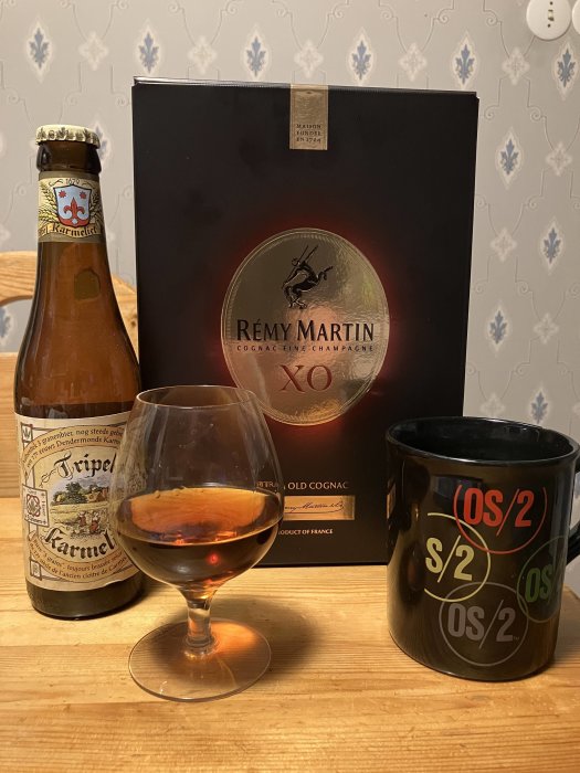 Ölflaska, Rémy Martin-cognacförpackning, snifterglas med dryck, mugg med text. Elegant dryckesuppläggning.