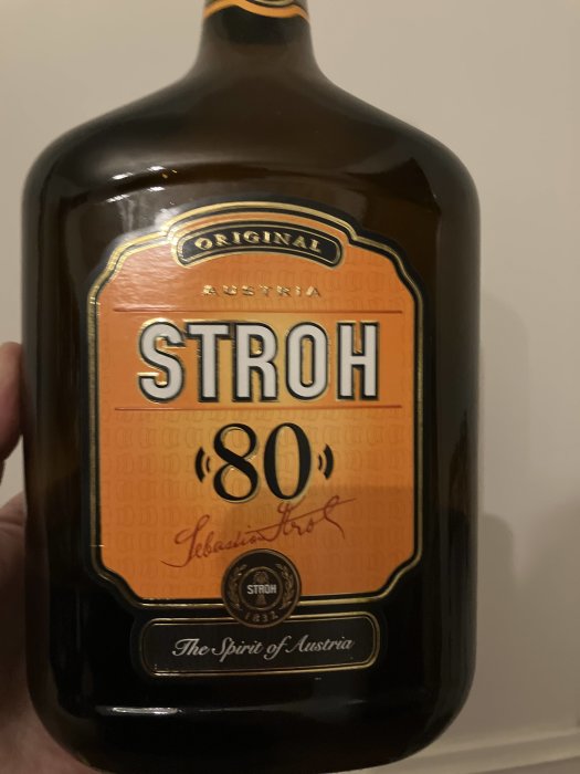 En flaska STROH 80, en österrikisk spritdryck, mot en osynlig bakgrund.