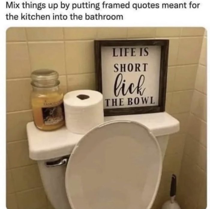 Humoristisk bild: toalett med inramad text "LIFE IS SHORT LICK THE BOWL", ljus, toalettpapper - kökscitat i badrum.