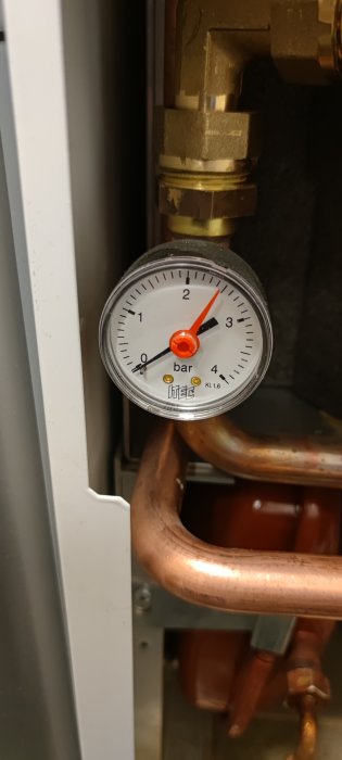 Manometer visar cirka 1.5 bar, kopplad till rörinstallation, troligen del av värmesystem eller vattenförsörjning.