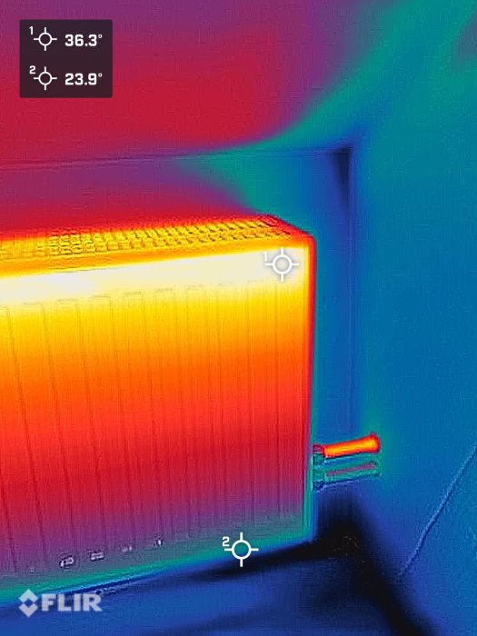 Termisk bild av en radiator, visar värmeutstrålning, FLIR-kamera använd, temperaturindikatorer visar olika grader.