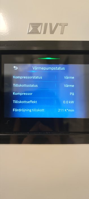 Digital skärm på en värmepump, visar status för olika komponenter och effektivitet; värmedrift är aktiverad.