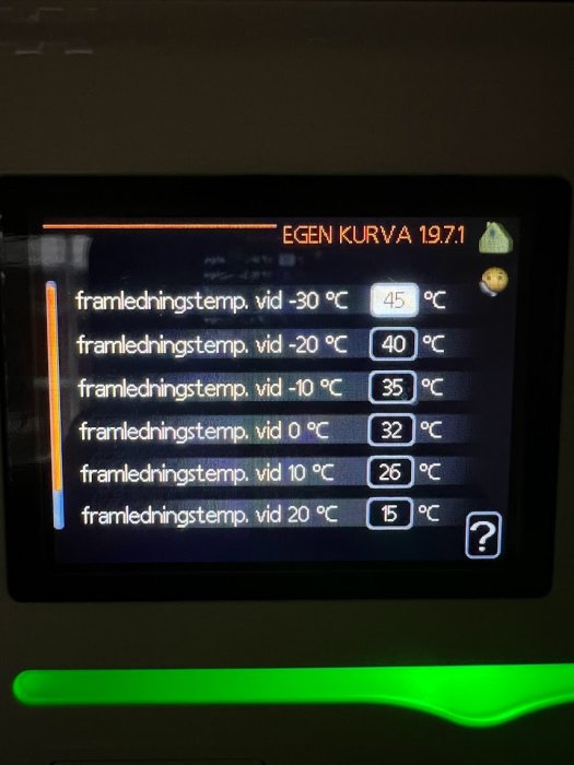 Digital display visar temperaturinställningar för olika utomhustemperaturer, sannolikt för ett värmesystem.