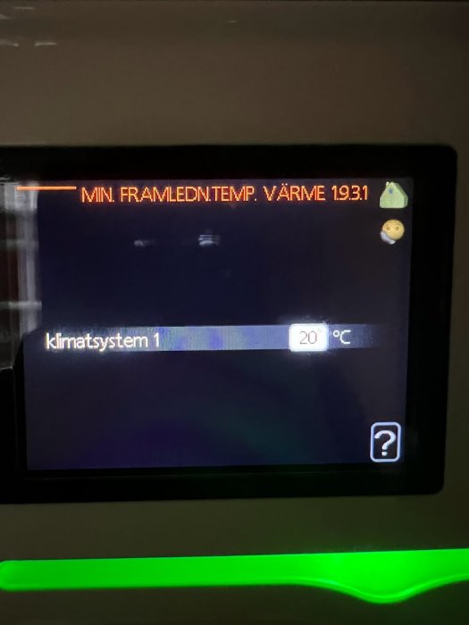 Digital display visar klimatsystem information, temperaturinställning 20°C, omgivande ljus, suddig bakgrund, inomhus.