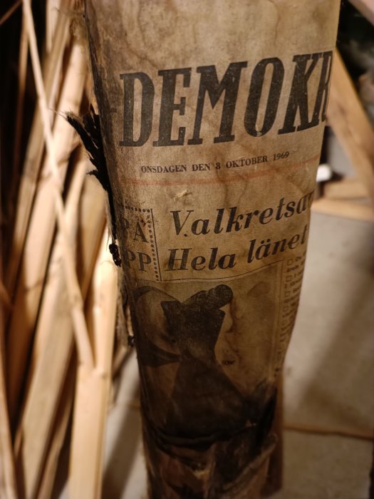 Gammal tidning, sannolikt svenskspråkig, datum 8 oktober 1969, ordet "DEMO" synligt, bruntonad, sliten, torkade växter.