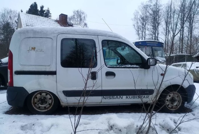 Vit Nissan Kubistar skåpbil parkerad i snöig miljö, vintertid, med smutsiga sidor och tak.