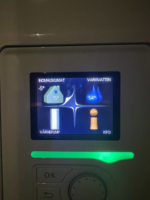 Digital display för värmesystem; visar inomhustemperatur, varmvatten och värmepumpstatus med blå belysning.