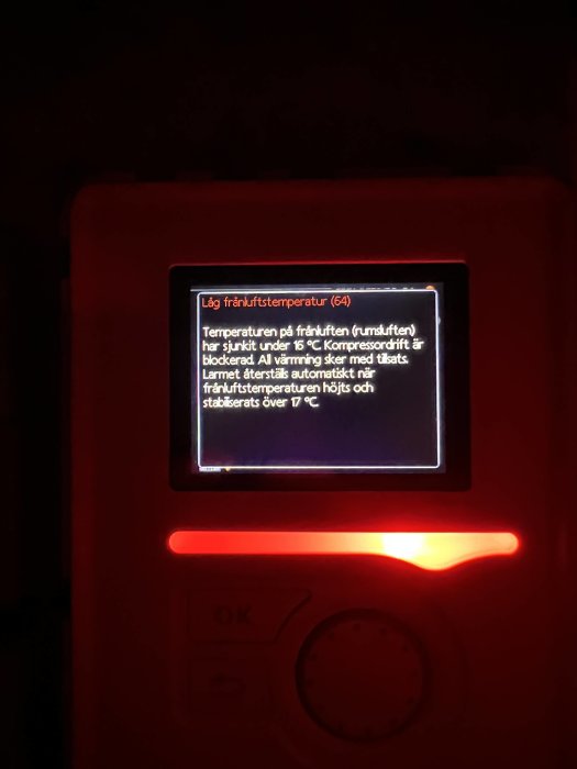 Digital display visar larm för låg frånluftstemperatur på svenska, röd belysning, knappar under skärmen.