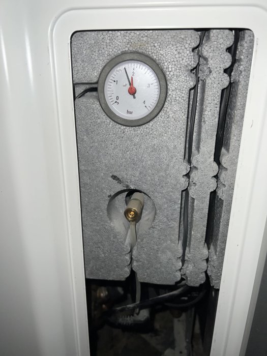 Manometer på en enhet, frostiga rör, vitt skåp, tekniskt underhåll, heminfrastruktur, kabelanslutningar, lågt tryck.
