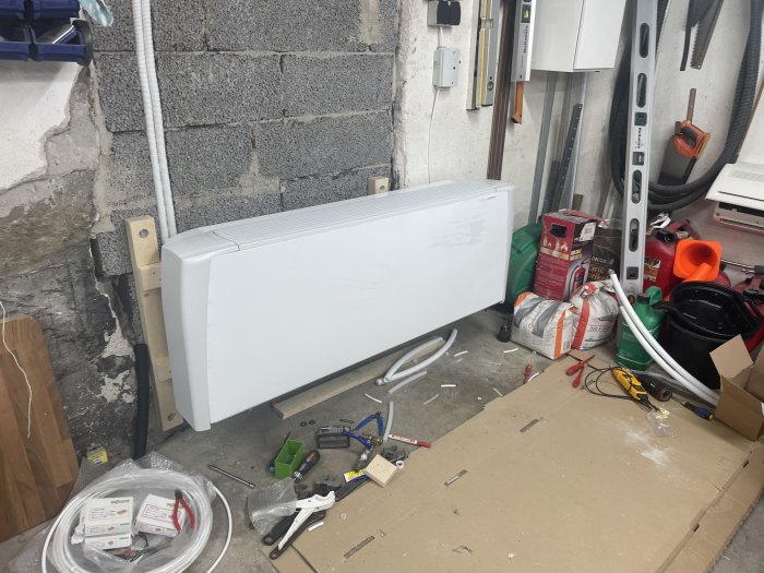Element, verktyg, installation, rörigt garage, grå betongvägg, inomhus, ledningar, elektricitetsskåp, förvaring.