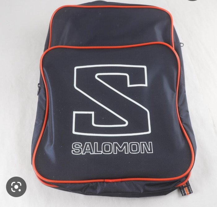 Svart ryggsäck med orange detaljer och "Salomon"-logotyp.