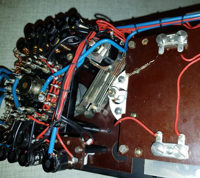 Elektroniskt kretskort med komponenter, kablar, och lödpunkter, del av en större apparat eller system.