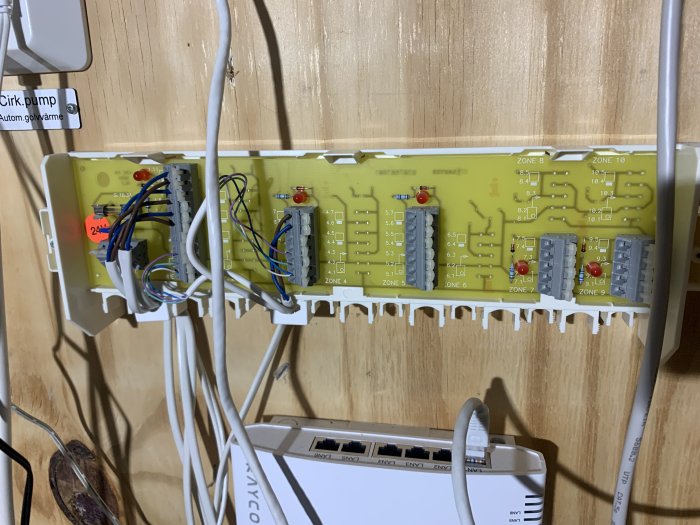 Kretskortsmoduler med kablar och terminaler monterade på en trävägg, del av ett elektroniksystem eller en automation.