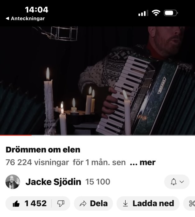 Man spelar dragspel, levande ljus, mörk bakgrund, video titel "Drömmen om elen", 76k visningar.