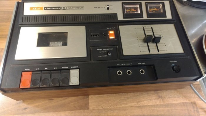 En Akai-bandspelare med VU-mätare, knappar och reglage för inspelning. Retro audio-utrustning. Vintage-teknologi på ett bord.