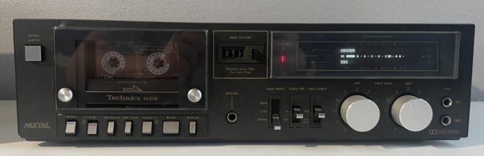 Kassettbandspelare, Technics M215, svart, knappar, räknare, nivåmätare, volymkontroller, retro, audio-utrustning.