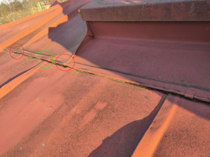 Tak med röda plåtar och märkta områden, möjlig skadedetektion eller reparation, solnedgångsskuggor.