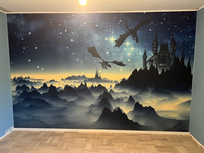 Väggmålning med stjärnhimmel, bergslandskap, dimma, slott och flygande drakar i ett rum.