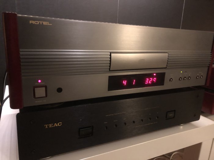 Två elektroniska komponenter, en Rotel CD-spelare ovanpå en TEAC-apparat, sannolikt i ett stereo-system.