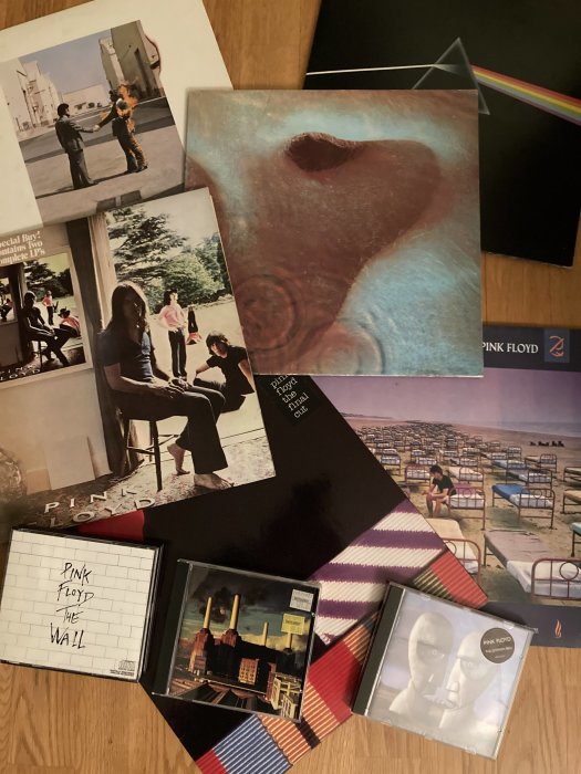 Samling av Pink Floyd-albumomslag på LP och CD, ikoniska bilder, musikhistoria, designelement, bandrekvisita.