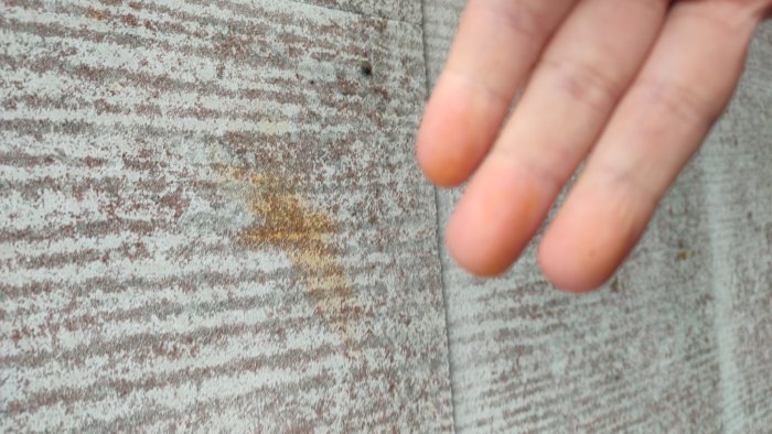 Hand nära rostig metal yta, texturfokus, utsnitt, oskärpa, detaljer.
