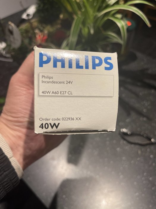 En person håller en Philips glödlampsförpackning för 40W E27 klart ljuskälla.