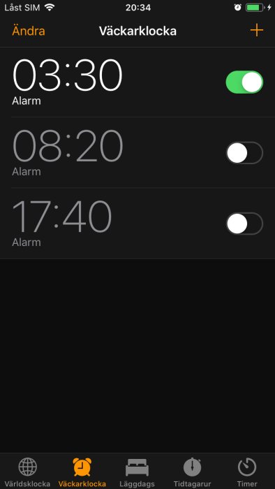 Skärm från mobilens alarmapp visande tre olika alarm, en aktiverad, på en mörk bakgrund.