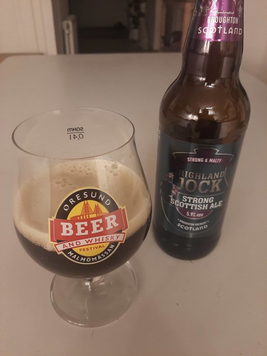 Ett ölglas nära fullt, "Öresund Beer and Whisky Festival"-logotyp, en flaska stark skotsk ale.