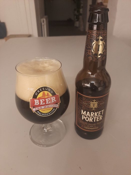 Ett glas mörk öl och en ölflaska med etiketten "Market Porter" vid sidan om.