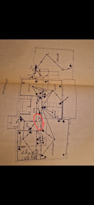 Arkitektonisk ritning av en husplan, skalenlig, innehållande rum, möblering och mått, markerad med röd cirkel.