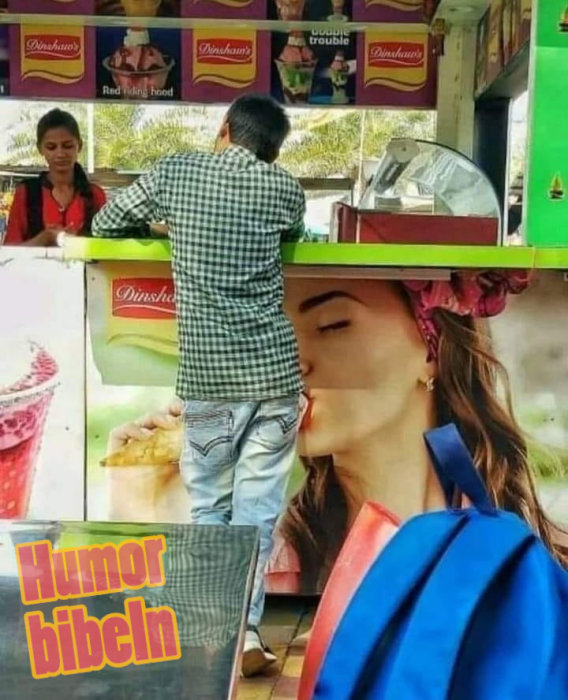 Reklam vid glasskiosk skapar optisk illusion av en kyss mellan en kund och affischansikte.