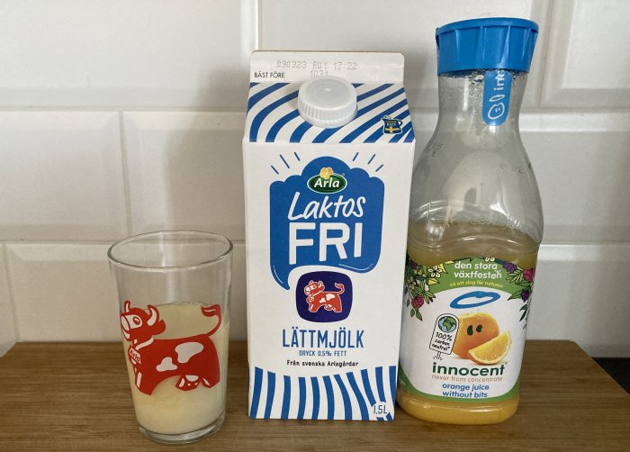 Ett glas mjölk, Arla laktosfri lättmjölk och Innocent apelsinjuice på köksbänken.