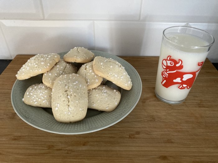Ett fat med kakor och ett glas mjölk på en köksbänk.