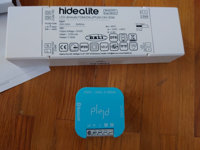 LED-dimmer för belysning med teknisk information och installationsanvisningar på lådan, placerad på ett träbord.