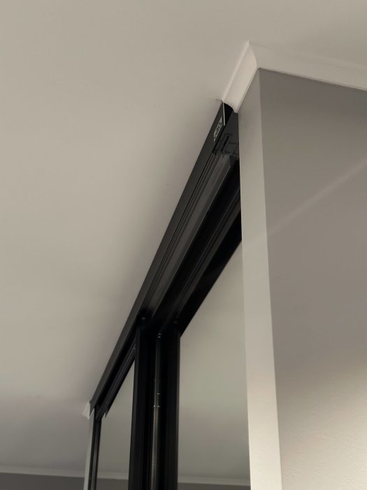 Svarta fönsterramar i vitt hörn, modern arkitektur, minimalistisk stil, inomhus.