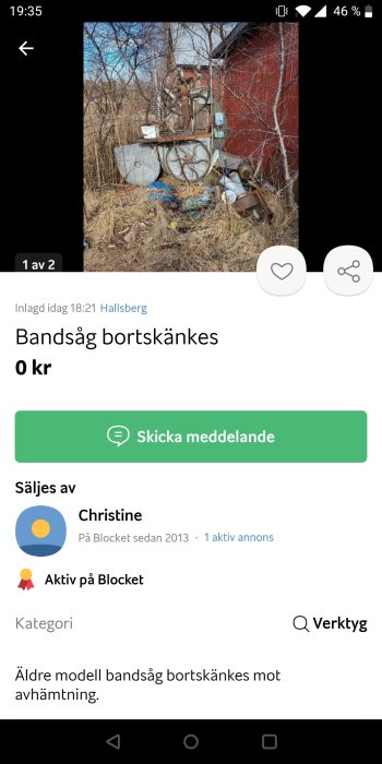 Gammal bandsåg bland bråte, kostnadsfri, utomhus mot röd byggnad, skogsmiljö, annonseras på köp-och-sälj-app.