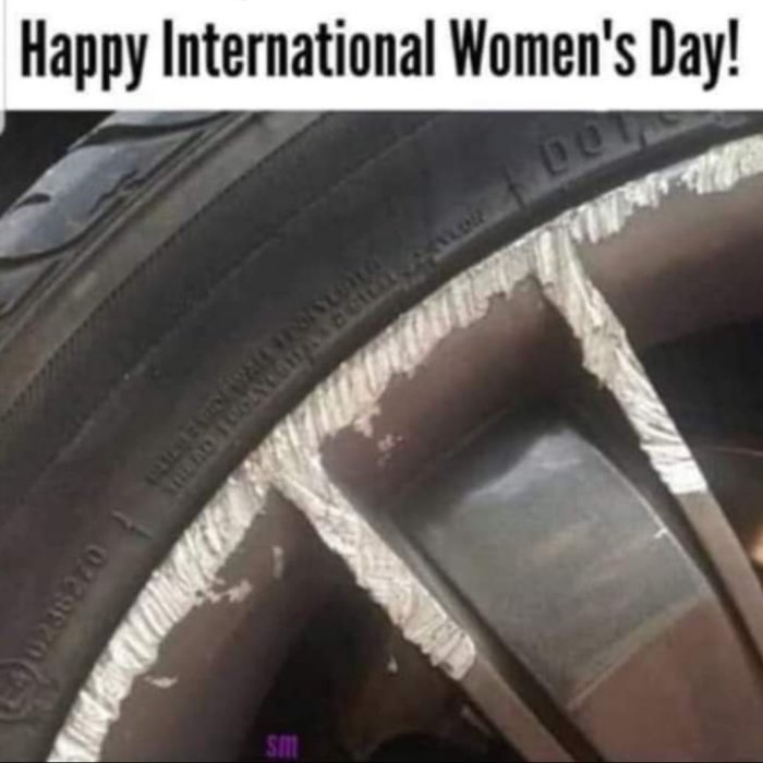 Bildtext: "Happy International Women's Day!". Närbild på sönderriven däckskant och fälg. Ironiskt eller otrevligt sammanhang.