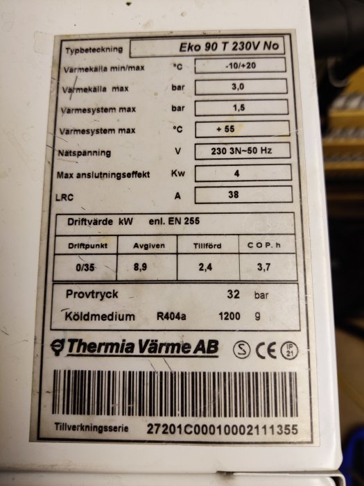 Teknisk etikett på maskin, visar specifikationer som temperatur, tryck, effekt, spänning, och kylmedium. Märkt med "Thermia Värme AB".