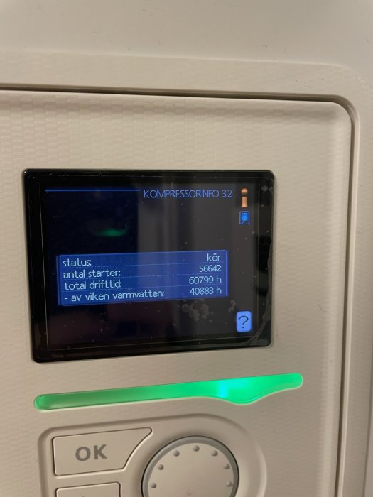En skärm visar driftinformation om en kompressor: status, antal starter, drifttid och varmvattentid. Knappar under.